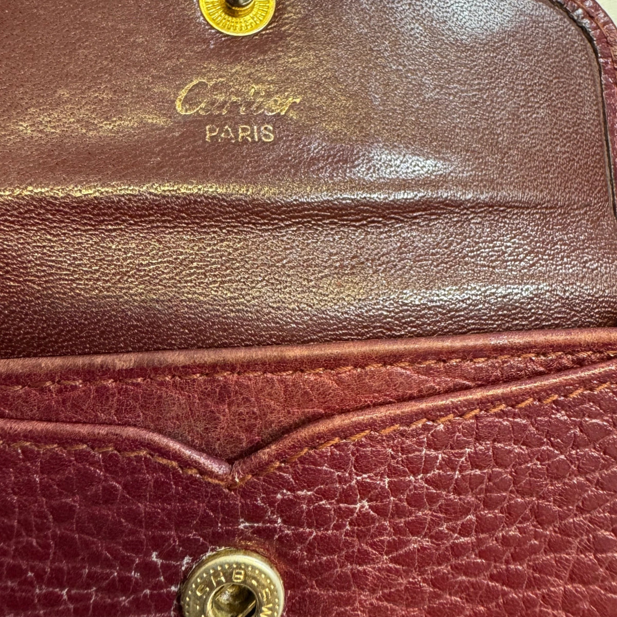 CARTIER Porte-monnaie demi-lune Cartier de la ligne must bordeaux