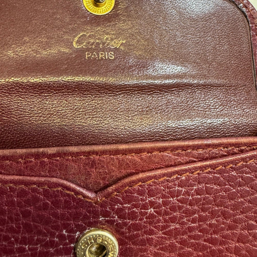 CARTIER Porte-monnaie demi-lune Cartier de la ligne must bordeaux